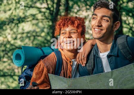 Junges, multiethnisches junges Paar auf einer Rucksacktour auf der Karte Stockfoto