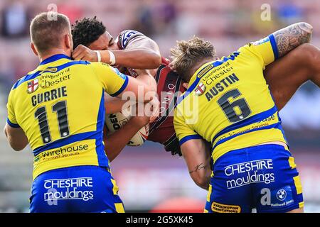 Kai Pearce-Paul (27) von Wigan Warriors wird von Blake Austin (6) und Ben Currie (11) von Warrington Wolves angegangen Stockfoto