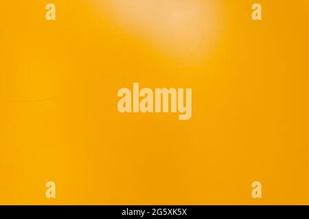 Strukturierte Wand in gelber Metallic-Optik. Hintergrund mit kleinen Kratzern. Wand des Hauses ist gelb gestrichen Stockfoto