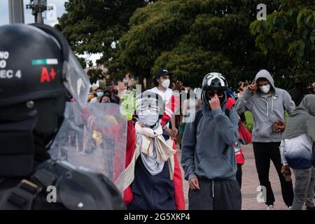 Bogota, Kolumbien. Juni 2021. Demonstranten wenden den Finger gegen die kolumbianische Bereitschaftspolizei (ESMAD), als die Bewohner von Fontanar - Suba in Bogota, Kolumbien, protestierten und gegen die kolumbianische Bereitschaftspolizei (Escuadron Movil Antidisturbios ESMAD) gegen den Besuch des kolumbianischen Präsidenten Ivan Duque Marquez in einem Park, in dem Bogotas U-Bahn-System gebaut werden soll, kollidierten. Inmitten von zwei Monaten regierungsfeindlicher Proteste gegen den Präsidenten Ivan Duque Marquez, Ungleichheiten und Polizeiunruhen während der Proteste am 29. Juni 2021. Kredit: Long Visual Press/Alamy Live Nachrichten Stockfoto