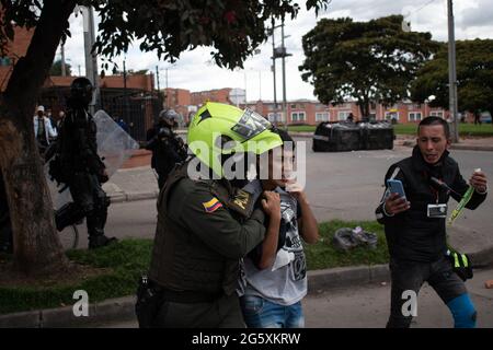 Bogota, Kolumbien. Juni 2021. Ein Demonstranten, der von der kolumbianischen Bereitschaftspolizei (ESMAD) verhaftet wurde, als die Einwohner von Fontanar - Suba in Bogota, Kolumbien, protestierten und gegen die kolumbianische Bereitschaftspolizei (Escuadron Movil Antidisturbios ESMAD) gegen den Besuch des kolumbianischen Präsidenten Ivan Duque Marquez in einem Park, in dem Bogotas U-Bahn-System gebaut wird, kollidierten. Inmitten von zwei Monaten regierungsfeindlicher Proteste gegen den Präsidenten Ivan Duque Marquez, Ungleichheiten und Polizeiunruhen während der Proteste am 29. Juni 2021. Kredit: Long Visual Press/Alamy Live Nachrichten Stockfoto