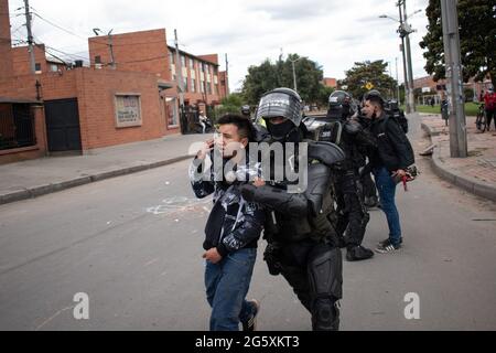 Bogota, Kolumbien. Juni 2021. Ein Demonstranten, der von der kolumbianischen Bereitschaftspolizei (ESMAD) verhaftet wurde, als die Einwohner von Fontanar - Suba in Bogota, Kolumbien, protestierten und gegen die kolumbianische Bereitschaftspolizei (Escuadron Movil Antidisturbios ESMAD) gegen den Besuch des kolumbianischen Präsidenten Ivan Duque Marquez in einem Park, in dem Bogotas U-Bahn-System gebaut wird, kollidierten. Inmitten von zwei Monaten regierungsfeindlicher Proteste gegen den Präsidenten Ivan Duque Marquez, Ungleichheiten und Polizeiunruhen während der Proteste am 29. Juni 2021. Kredit: Long Visual Press/Alamy Live Nachrichten Stockfoto