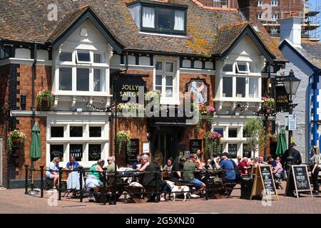 Poole, England - 2021. Juni: Menschen, die bei sommerlicher Sonne vor dem Jolly Sailor Pub am Wasser in Poole sitzen Stockfoto