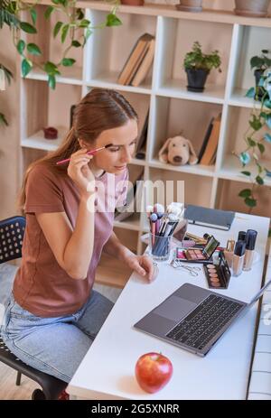 Attraktive Dame mit einem Augenbrauenpinsel zu Hause Stockfoto