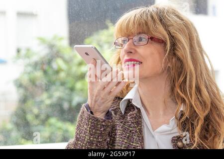 Frau, die Sprachnachricht auf dem Mobiltelefon sendet Stockfoto