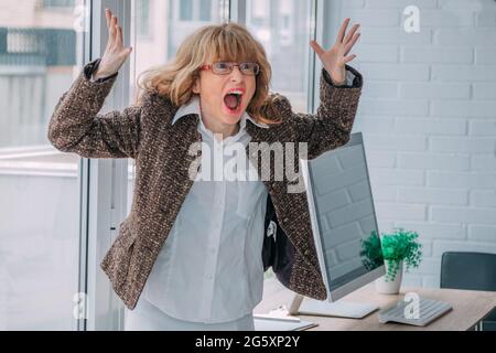 Wütende Geschäftsfrau, die im Büro schreit Stockfoto