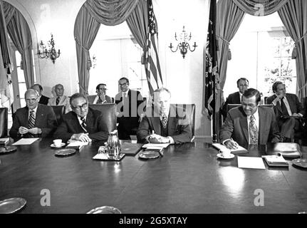 Der Präsident der Vereinigten Staaten, Gerald R. Ford, berichtet über sein Kabinett, nachdem er am 29. Juni 1976 vom zweitägigen internationalen Wirtschaftsgipfel am Dorado Beach, Puerto Rico, im Kabinettsaal des Weißen Hauses in Washington, DC zurückgekehrt war. Am Tisch sitzen, von links nach rechts: US-Innenminister Thomas S. Kleppe, US-Außenminister Henry A. Kissinger, Präsident Ford und US-Verteidigungsminister Donald H. Rumsfeld. In der hinteren Reihe von links nach rechts sitzen: L. William Seidman, Executive Director of the Economic Policy Board und Assistant for Economic Affairs; Alan Greenspan, Stockfoto