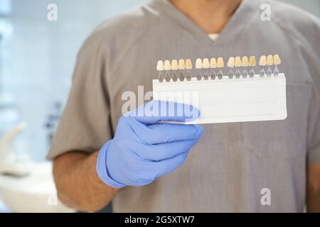 Zahnarzt posiert mit Zahnweiß-Kit in seinem Büro Stockfoto