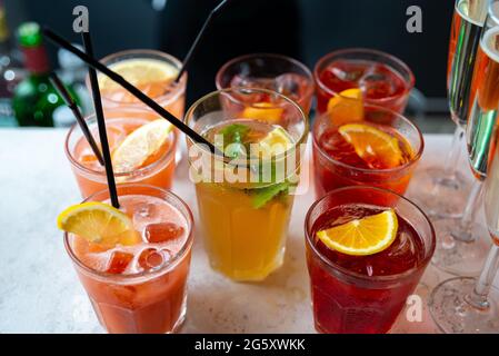 Cocktails und Champagner in einem Glas auf dem Bartisch für Partygäste. Dunkler Hintergrund der Loftwand. Stockfoto