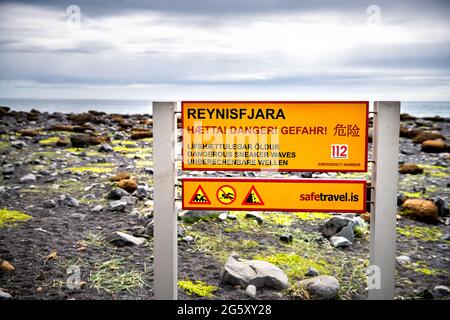 Myrdal, Island - 14. Juni 2018: Reynisfjara schwarzer Sandstrand mit Warnschild für gefährliche Sneaker-Wellen, die Menschen ins Meer ziehen und zu führen können Stockfoto