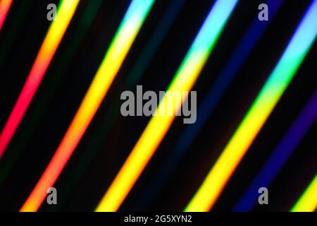 Neon-Regenbogenstreifen auf dunklem Hintergrund. Weicher Fokus Abstraktes Regenbogenfarben Wellenstreifen horizontaler Hintergrund. Stockfoto