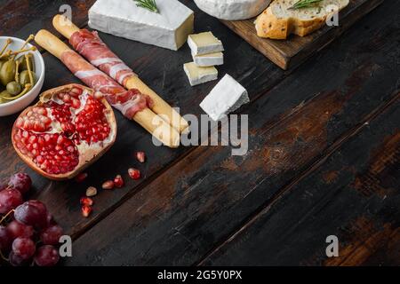 Vorspeisen-Tisch mit verschiedenen Antipasti-Set, auf dunklem Holzhintergrund mit Platz für Text Stockfoto