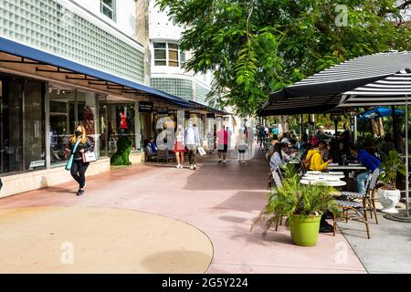 Miami Beach, USA - 17. Januar 2021: Berühmte Lincoln Road Einkaufsstraße mit Menschen, die auf dem Bürgersteig beim Restaurant Cafe im Freien essen Stühle auf s gehen Stockfoto