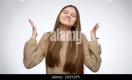 Glücklich jubelnde Mädchen nach dem Gewinn in der Lotterie suchen und Heben der Hände über weißen Studio Hintergrund Stockfoto