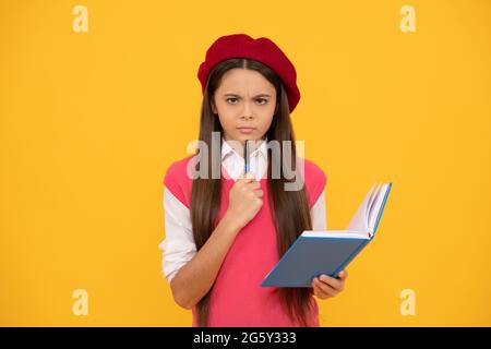 Serious teen Schulmädchen in französisch Baskenmütze Notizen in Planer Notizblock oder Notizbuch, Studie Stockfoto