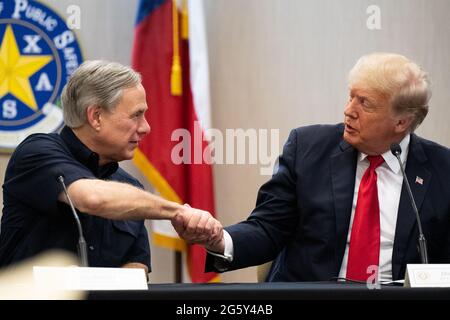 WESLACO, TEXAS - JUNI 30: Texas Gov. GREG ABBOTT und der ehemalige Präsident DONALD TRUMP schütteln sich die Hände während einer Sicherheitsbesprechung am 30. Juni 2021 in Weslaco, Texas. Gov. Abbott hat zugesagt, eine staatlich finanzierte Grenzmauer zwischen Texas und Mexiko zu errichten, da ein Anstieg von hauptsächlich mittelamerikanischen Einwanderern, die in die Vereinigten Staaten einwandern, die US-Einwanderungsbehörden herausgefordert hat. Bisher haben Agenten der US-Grenzpolizei im Jahr 2021 mehr als 900,000 Einwanderer festgenommen, die an der Südgrenze in die Vereinigten Staaten einwanderten. POOL/Brandon Bell Stockfoto
