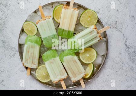 Sommer erfrischend hausgemachte Limettenpopsicles mit abgebrochtem Eis auf Stein Hintergrund Stockfoto