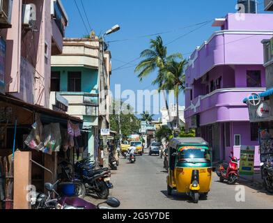 Indische Auto-Rikscha fährt vorbei an pastellfarbenen Gebäuden im Art-déco-Stil in Puducherry (Pondicherry), tamil Nadu, Indien Stockfoto