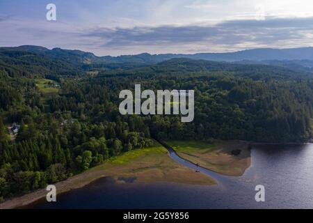 Loch Venachar, Loch. Lomonnd und Trossachs National Park, Schottland, Großbritannien. 30. Juni 2021. IM BILD: Eine Weitwinkelansicht des Kies- und Steinstrandes am Loch Venachar, der normalerweise unter ein paar Fuß Wasser liegt, ist aufgrund der schwindenden Wasserversorgung, die aufgebraucht ist, freigelegt. An diesem Teil des loch sollte es keinen Strand geben, aber man kann sehen, wie die Leute diesen Make Shift-Strand benutzen, um die Abendsonne zu genießen. Quelle: Colin Fisher/Alamy Live News Stockfoto