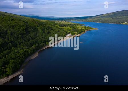 Loch Venachar, Loch. Lomonnd und Trossachs National Park, Schottland, Großbritannien. 30. Juni 2021. IM BILD: Eine Weitwinkelansicht des Kies- und Steinstrandes am Loch Venachar, der normalerweise unter ein paar Fuß Wasser liegt, ist aufgrund der schwindenden Wasserversorgung, die aufgebraucht ist, freigelegt. An diesem Teil des loch sollte es keinen Strand geben, aber man kann sehen, wie die Leute diesen Make Shift-Strand benutzen, um die Abendsonne zu genießen. Quelle: Colin Fisher/Alamy Live News Stockfoto