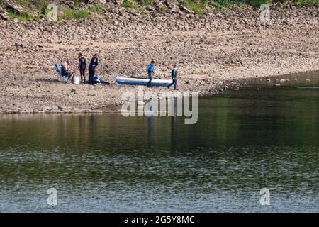 Loch Venachar, Loch. Lomonnd und Trossachs National Park, Schottland, Großbritannien. 30. Juni 2021. IM BILD: Leute auf dem Wasser paddeln, Kajakfahren, wildes Schwimmen und genießen das heiße Sommerwetter während einer Zeit, in der die schottischen Seen von Wasser erschöpft sind. Der große steinerne Strand liegt um den loch herum, der normalerweise komplett unter Wasser wäre, aber bei dem langen trockenen und heißen Wetter gibt es nichts, was das verdunstende Wasser ersetzen könnte. Quelle: Colin Fisher/Alamy Live News Stockfoto