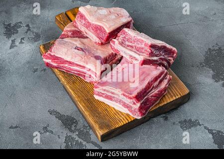 RAW Bio Rindfleisch kurze Rippen bereit zum Kochen Set, auf grauem Stein Hintergrund Stockfoto