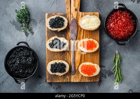 Sandwiches mit rotem und schwarzem Kaviar, auf grauem Hintergrund, Draufsicht flach liegend Stockfoto