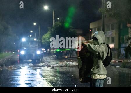 Bogota, Kolumbien. Juni 2021. Ein Demonstrator, der einen selbstgemachten Schild verwendet, weist einen Faulenzer auf einen gepanzerten Lastwagen, während regierungsfeindliche Proteste inmitten politischer Spannungen gegen die Regierung von Präsident Ivan Duque zu Zusammenstößen zwischen Demonstranten und der kolumbianischen Bereitschaftspolizei (ESMAD) führen, Fälle von Polizeibrutalität und Ungleichheiten, da Kolumbien am 28. Juni 2021 in Bogota, Kolumbien, einen zweiten Monat der Anti-Regierung-Proteste feiert. Kredit: Long Visual Press/Alamy Live Nachrichten Stockfoto