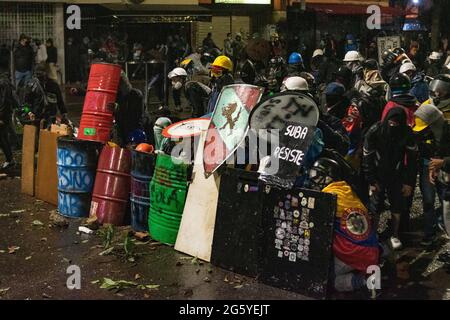 Bogota, Kolumbien. Juni 2021. Mitglieder der ersten Linie der „Primera-Linie“ verwenden selbstgemachte Schilde, während regierungsfeindliche Proteste zu Zusammenstößen zwischen Demonstranten und der kolumbianischen Bereitschaftspolizei (ESMAD) führen, inmitten politischer Spannungen gegen die Regierung von Präsident Ivan Duque, polizeilicher Brutalität und Ungleichheiten, da Kolumbien einen zweiten Monat lang regierungsfeindliche Proteste in Bogota feiert, Kolumbien am 28. Juni 2021. Kredit: Long Visual Press/Alamy Live Nachrichten Stockfoto