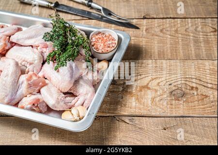 Rohe Hähnchenflügel Geflügelfleisch bereit zum Kochen mit Kräutern. Holzhintergrund. Draufsicht. Speicherplatz kopieren Stockfoto