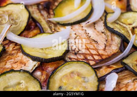 Nahaufnahme der Pizza mit gegrillter Aubergine, Zucchini und Zwiebeln. Makroaufnahme köstlicher Produkte. Stockfoto