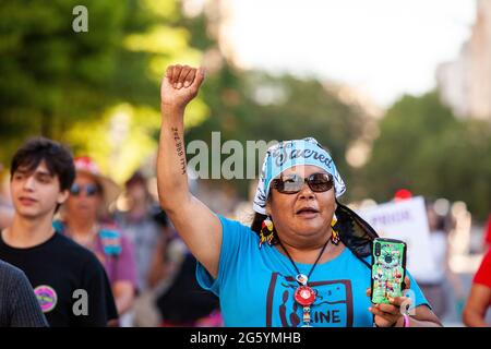 Washington, DC, USA. 30. Juni 2021. Im Bild: Eine indigene Klimaaktivistin marschiert mit der Faust hoch während eines Protestes, bei dem die Regierung und der Kongress von Biden aufgerufen werden, der Klimagerechtigkeit und den indigenen Rechten Vorrang einzuräumen und die weitere Entwicklung der fossilen Energiegewinnung zu stoppen. Kredit: Allison Bailey/Alamy Live Nachrichten Stockfoto