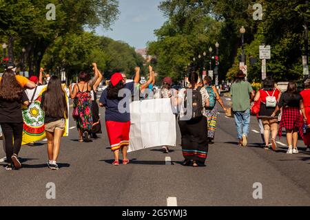 Washington, DC, USA. 30. Juni 2021. Im Bild: Demonstranten marschieren während der morgendlichen Hauptverkehrszeit mit erhobenen Fäusten auf der Constitution Avenue in der Innenstadt von Washington. Sie fordern die Regierung und den Kongress von Biden auf, der Klimagerechtigkeit und den indigenen Rechten Vorrang einzuräumen und die weitere Entwicklung der fossilen Energiegewinnung zu stoppen. Kredit: Allison Bailey/Alamy Live Nachrichten Stockfoto