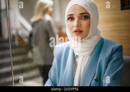 Nahaufnahme eines Porträts einer muslimischen Frau mit Kopftuch im Café Stockfoto