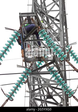 Elektriker arbeitet an einem Pol, Hochspannung Stockfoto