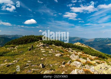 Herrliche Aussicht vom Varful Zlata-Gipfel über dem Zanoaga-See in den Retezat-Bergen in Rumänien mit vielen Hügeln und blauem Himmel mit Wolken Stockfoto