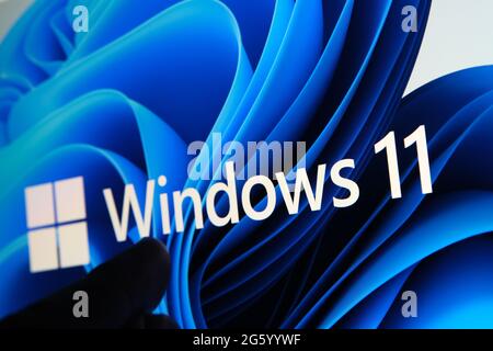 Windows 11-Logo auf dem Bildschirm des Tablets und Benutzer mit dem Finger auf sie zu sehen. Stafford, Großbritannien, 1. Juli 2021 Stockfoto