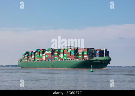 Stade, Deutschland - 25. Juni 2021: Das Containerschiff TAMPA TRIUMPH, das sich im Besitz von Costamare befindet und von Evergreen Marine betrieben wird, fährt auf der Elbe nach Hamburg Stockfoto