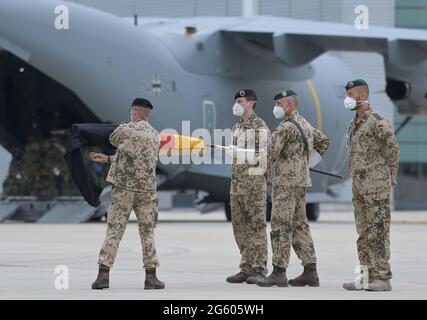 Wunstorf, Deutschland. 30. Juni 2021. Brigadegeneral Ansgar Meyer (l.), der letzte Kommandant der Bundeswehr in Afghanistan, rollt die Truppenflagge vor dem Transportflugzeug Airbus A400M der Luftwaffe. Die letzten Soldaten der deutschen Afghanistan-Mission sind auf dem Luftstützpunkt in Niedersachsen angekommen. Die Mission war am Vorabend nach fast 20 Jahren beendet. Die Soldaten waren mit vier Militärflugzeugen aus dem Feldlager in Masar-i-Sharif im Norden Afghanistans geflogen. Quelle: Hauke-Christian Dittrich/dpa-Pool/dpa/Alamy Live News Stockfoto