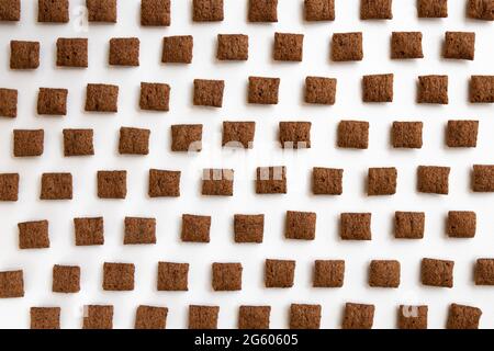 Schokoladen-Maispads isoliert auf weißem Hintergrund, Lebensmittelzutat, Schokoladenkorngetreide zum Frühstück, Haufen mit zuckerbeschichteten Maisflocken, Schnitzel Stockfoto