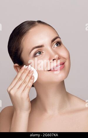 Frau, Die Gesicht Mit Weißem Pad Putzen. Schöne Mädchen Entfernen Make-Up White Kosmetik-Baumwoll-Pad. Happy Smiling Female Taking Off Make-Up Von Der Gesichtshaut Stockfoto