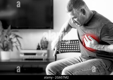 Der Mann hat Brustschmerzen, die durch einen Herzinfarkt verursacht werden. Herzkrankheit bei einem älteren Mann mit einem schwarz-weißen isolierten Hintergrund. Das Konzept der Medica Stockfoto