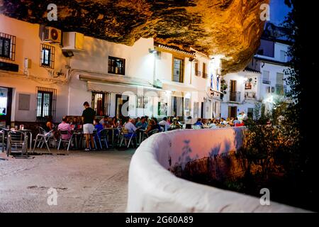 Touristen genießen gutes Essen und Getränke in den Restaurants von Setenil de las Bodegas, Andalusien, Spanien Stockfoto