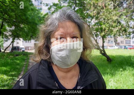 Ältere Frau Nahaufnahme Porträt im Freien mit schützender Coronavirus-Maske Stockfoto