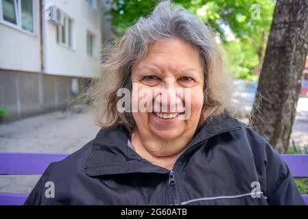 Ältere jüdische Dame lächelnd Porträt im Freien im Frühjahr Stockfoto