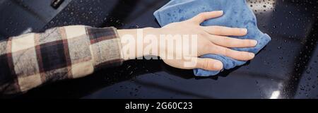 Beschnittene Ansicht des Mannes mit Putzlappen nasses Auto, Banner Stockfoto