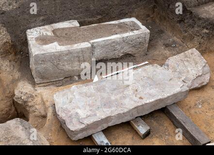 Eisleben, Deutschland. Juli 2021. Ein geöffneter Sarkophag liegt an der Stelle des ehemaligen königlichen Palastes von Helfta. Archäologen des Landesamtes für Denkmalpflege und Archäologie Sachsen-Anhalt hatten bereits vor Wochen damit begonnen, die Grundmauern der Kirche Kaiser Ottos des Großen (912-973) aufzudecken. Dabei stießen die Archäologen auf eine große Anzahl von Bestattungen, darunter mehrere Steinkrypten aus dem 10. Bis 15. Jahrhundert. Quelle: dpa picture Alliance/Alamy Live News Stockfoto