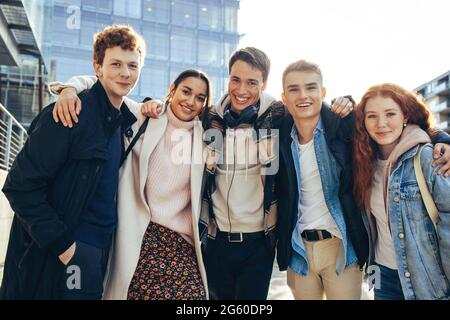 Porträt glücklicher junger Menschen in der Universität. College-Freunde stehen zusammen und posieren im Freien. Stockfoto