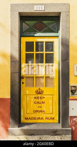 Gelb gestrichene Tür in der engen gepflasterten Straße Rua de Santa Maria, Funchal, Madeira Island, Portugal Stockfoto