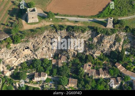 LUFTAUFNAHME. Zwei mittelalterliche Türme, die auf einer Klippe über einem alten Dorf stehen, und einige Steilküsten. Cotignac. Var, Frankreich. Stockfoto